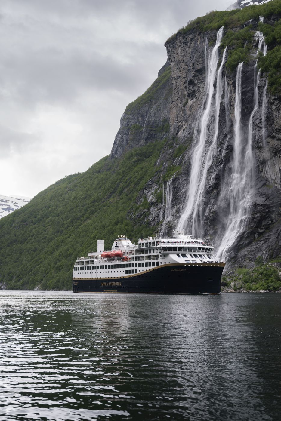 Die Castor, ein Schwesterschiff der Pollux, fährt durch den Geirangerfjord. Im Hintergrund sind die bekannten Wasserfälle „Die sieben Schwestern“ zu sehen.