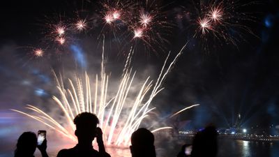 Menschen filmen ein Feuerwerk auf dem Circular Quay während der Feierlichkeiten zum «Australia Day». +++ dpa-Bildfunk +++