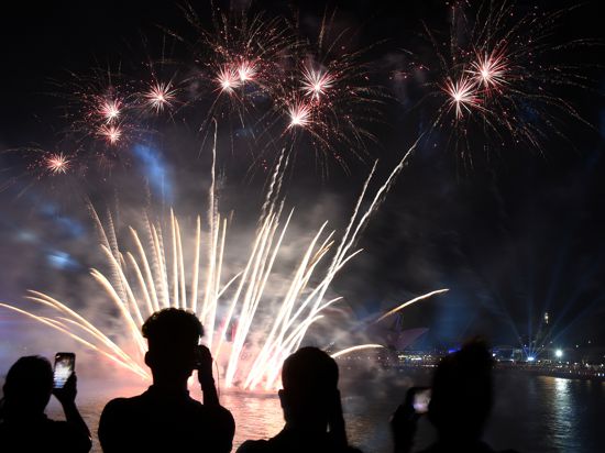 Menschen filmen ein Feuerwerk auf dem Circular Quay während der Feierlichkeiten zum «Australia Day». +++ dpa-Bildfunk +++