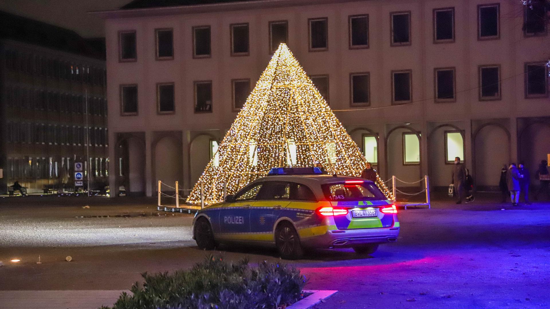 Ein Polizeiauto vor der beleuchteten Pyramide auf dem Karlsruher Marktplatz.