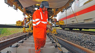 Bahnarbeiter im Einsatz: Mitabeiter bereitet die Schwelle zur Aufnahme der Schiene vor. 