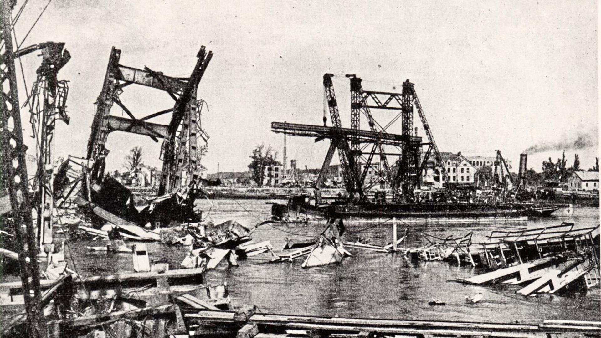 „Fliegende Festungen“ hatten die Rheinbrücke bei Karlsruhe lediglich zu beschädigen vermocht – zerstört wurde sie im Januar 1945 bei einem Jagdbomber-Angriff. 14 Männer, die gerade bei Reparaturarbeiten waren, wurden dabei getötet. Auf dem Foto, das nach Kriegsende entstand, ist neben den Resten der Eisenbahnbrücke eine von den Franzosen errichtete Pontonbrücke zu sehen.