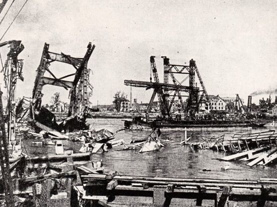„Fliegende Festungen“ hatten die Rheinbrücke bei Karlsruhe lediglich zu beschädigen vermocht – zerstört wurde sie im Januar 1945 bei einem Jagdbomber-Angriff. 14 Männer, die gerade bei Reparaturarbeiten waren, wurden dabei getötet. Auf dem Foto, das nach Kriegsende entstand, ist neben den Resten der Eisenbahnbrücke eine von den Franzosen errichtete Pontonbrücke zu sehen.