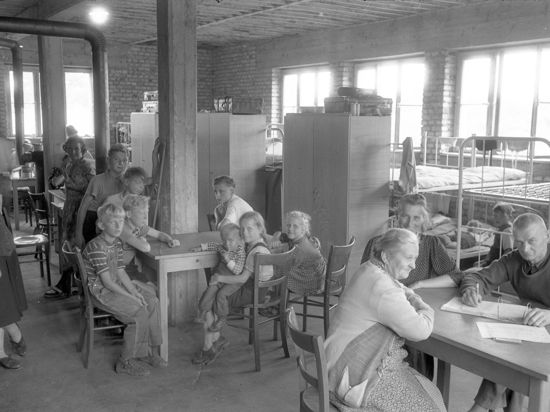Durchgangslager für Sowjetzonenflüchtlinge in der Appenmühle. Blick in einen Gemeinschaftssaal. Tische, im Hintergrund doppelstöckige Betten und Schränke.