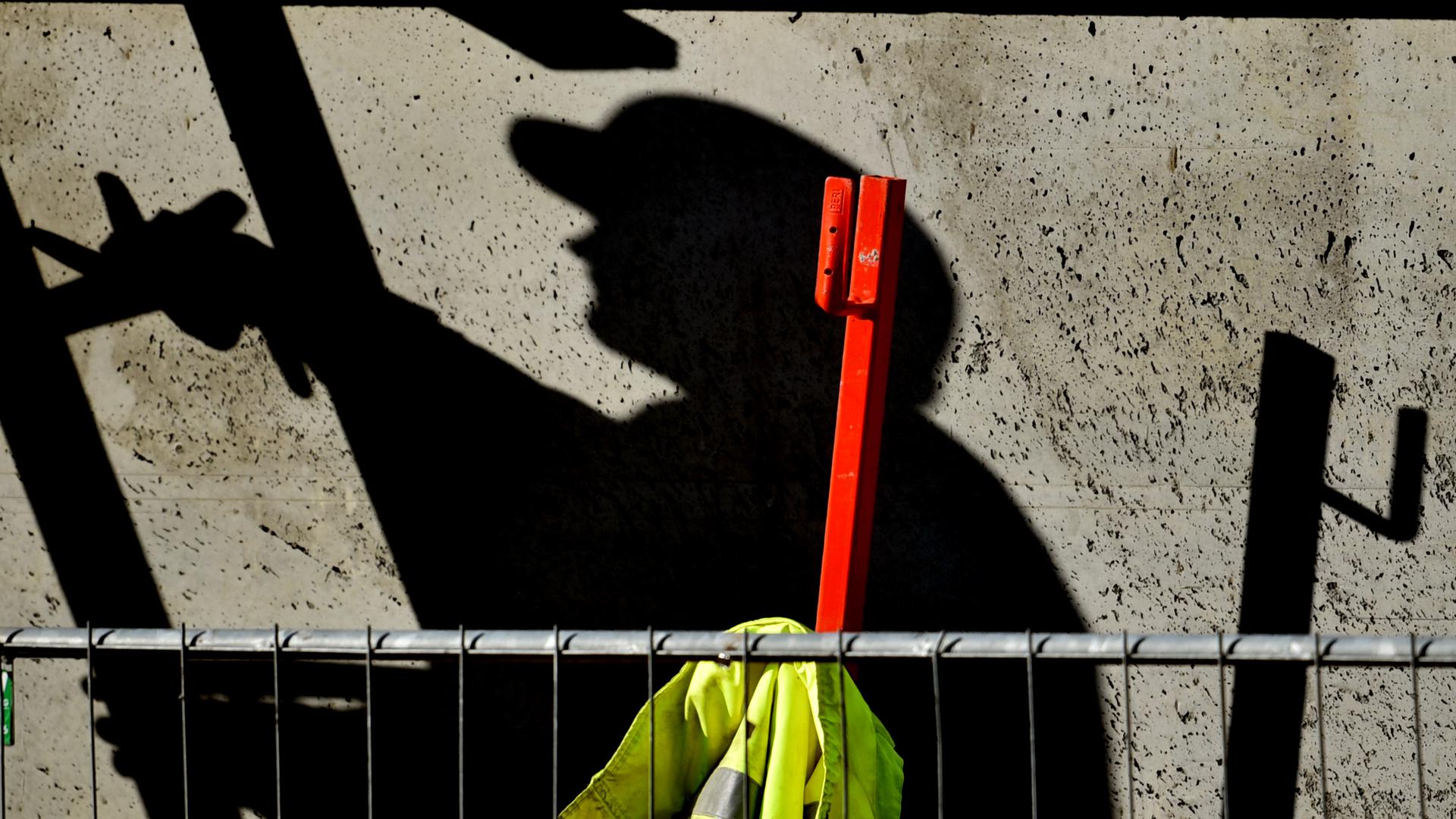 ARCHIV - 05.02.2015, Brandenburg, Potsdam: Illustration - Ein Arbeiter ist auf einer Baustelle beschäftigt und wirft dabei einen dunklen Schatten. (zu dpa «Gewerkschaft: Auf dem Bau sinkt die «Corona-Disziplin»») Foto: Ralf Hirschberger/dpa-Zentralbild/dpa +++ dpa-Bildfunk +++