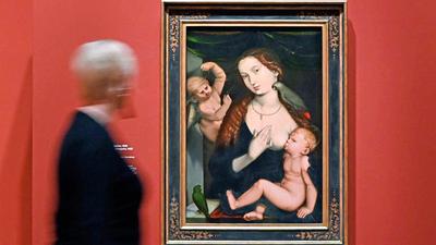 Ein verschwommener Mensch geht an einem Gemälde von Maria vorbei