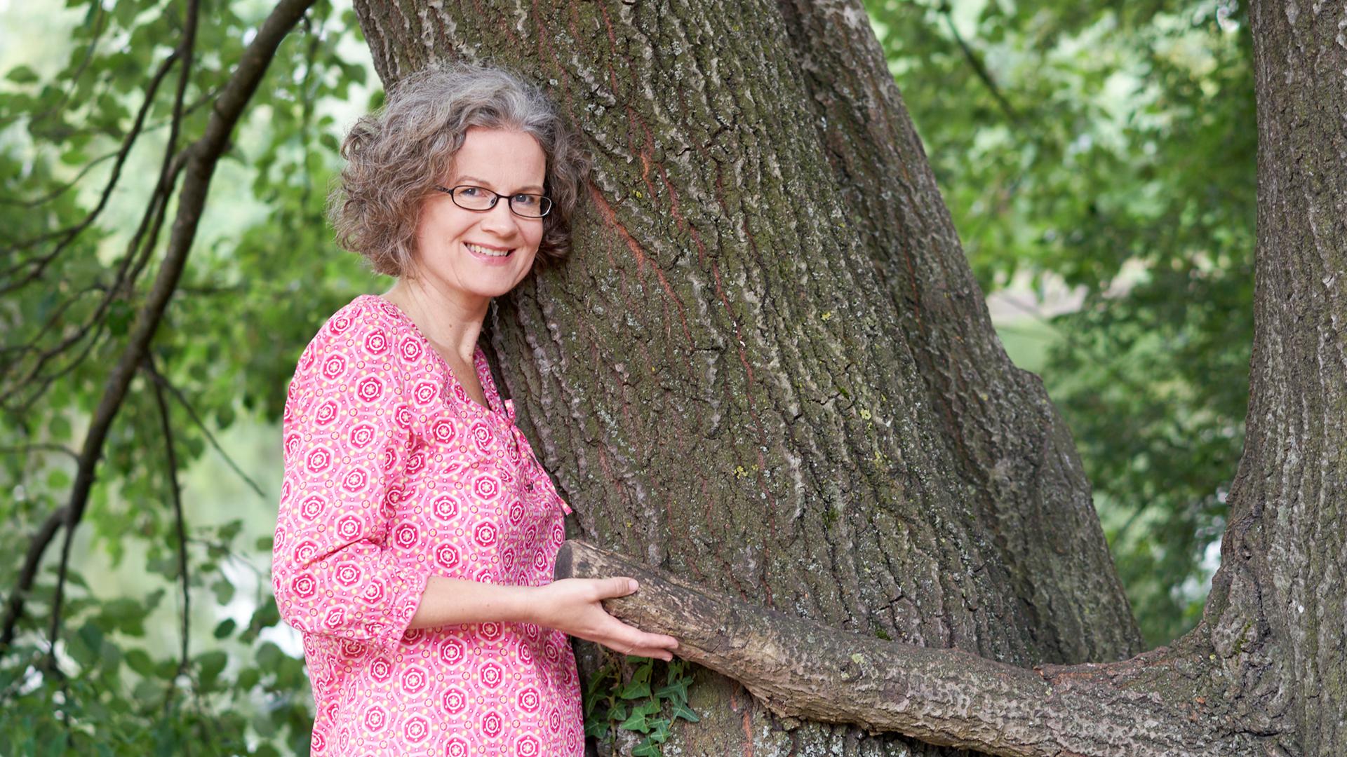 Kommunikationsexpertin Bettina Doll an einem Baum