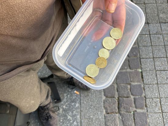 Bettler in der Kaiserstraße mit Geldschale in der Hand