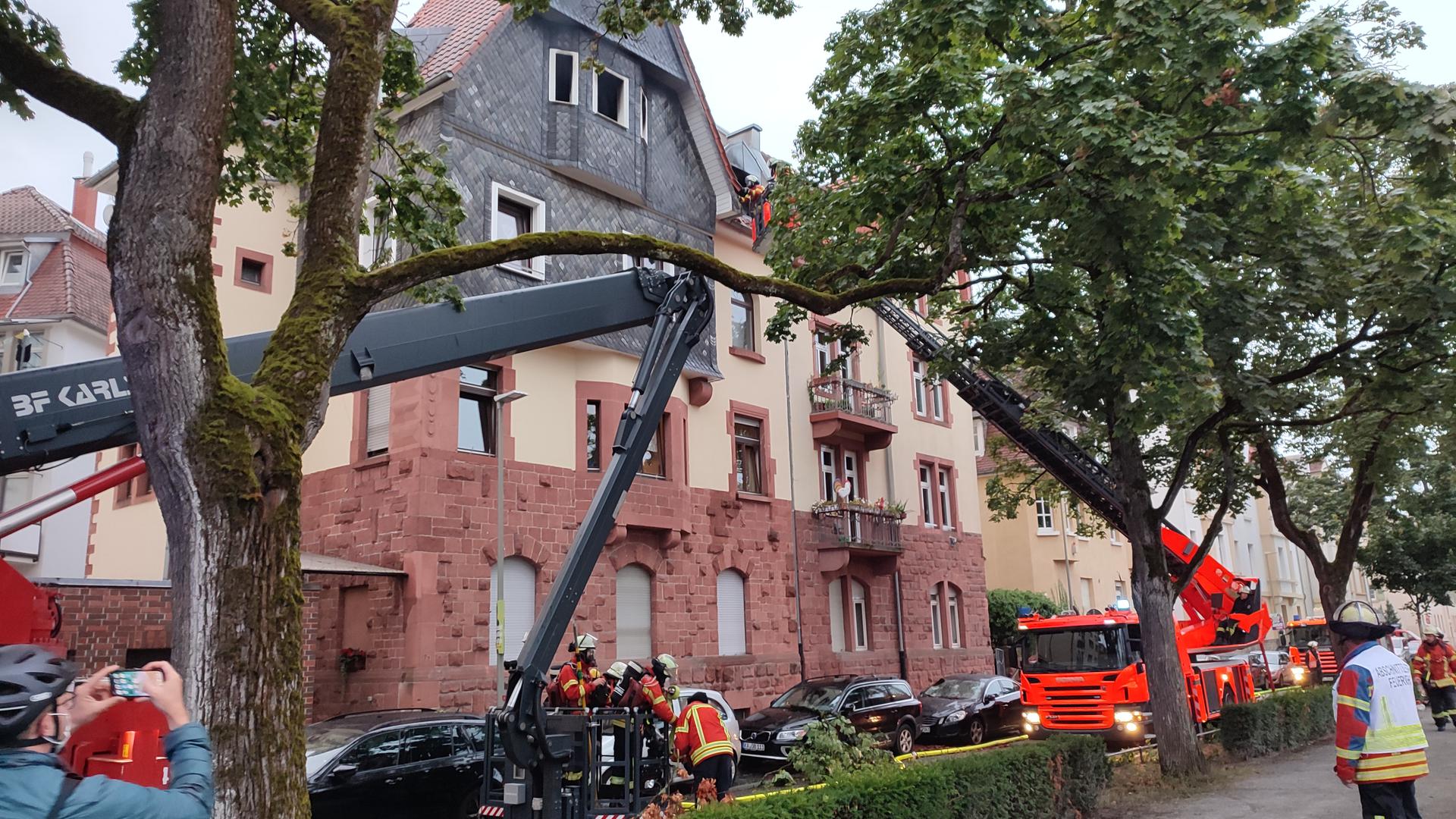 Feuerwehrfahrzeuge und Feuerwehrleute vor einem Haus in Mühlburg, ausgefahrene Drehleitern