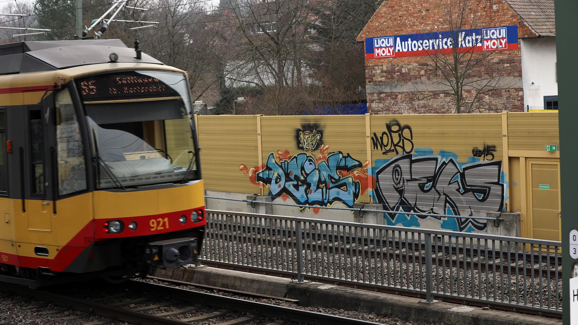 Straßenbahn neben Lärmschutzwand mit Graffiti