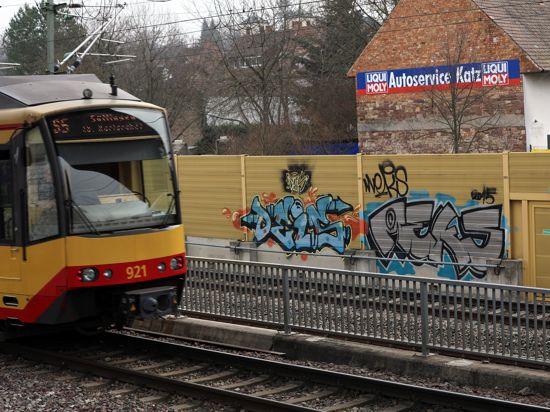 Straßenbahn neben Lärmschutzwand mit Graffiti