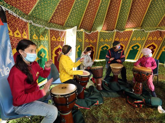 Sie haben den Rhythmus raus: Jochen Werner übt das Trommeln mit den Teilnehmerinnen des Kinderkulturfestival KiX im Otto-Dullenkopf-Park. 
