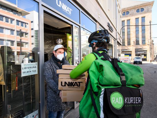 Kontaktlos und direkt: Der Bote von Radkurier Karlsruhe holt beim Modegeschäft Unikat bestellte Ware ab, um sie im Anschluss an die Kunden im Stadtgebiet auszuliefern.