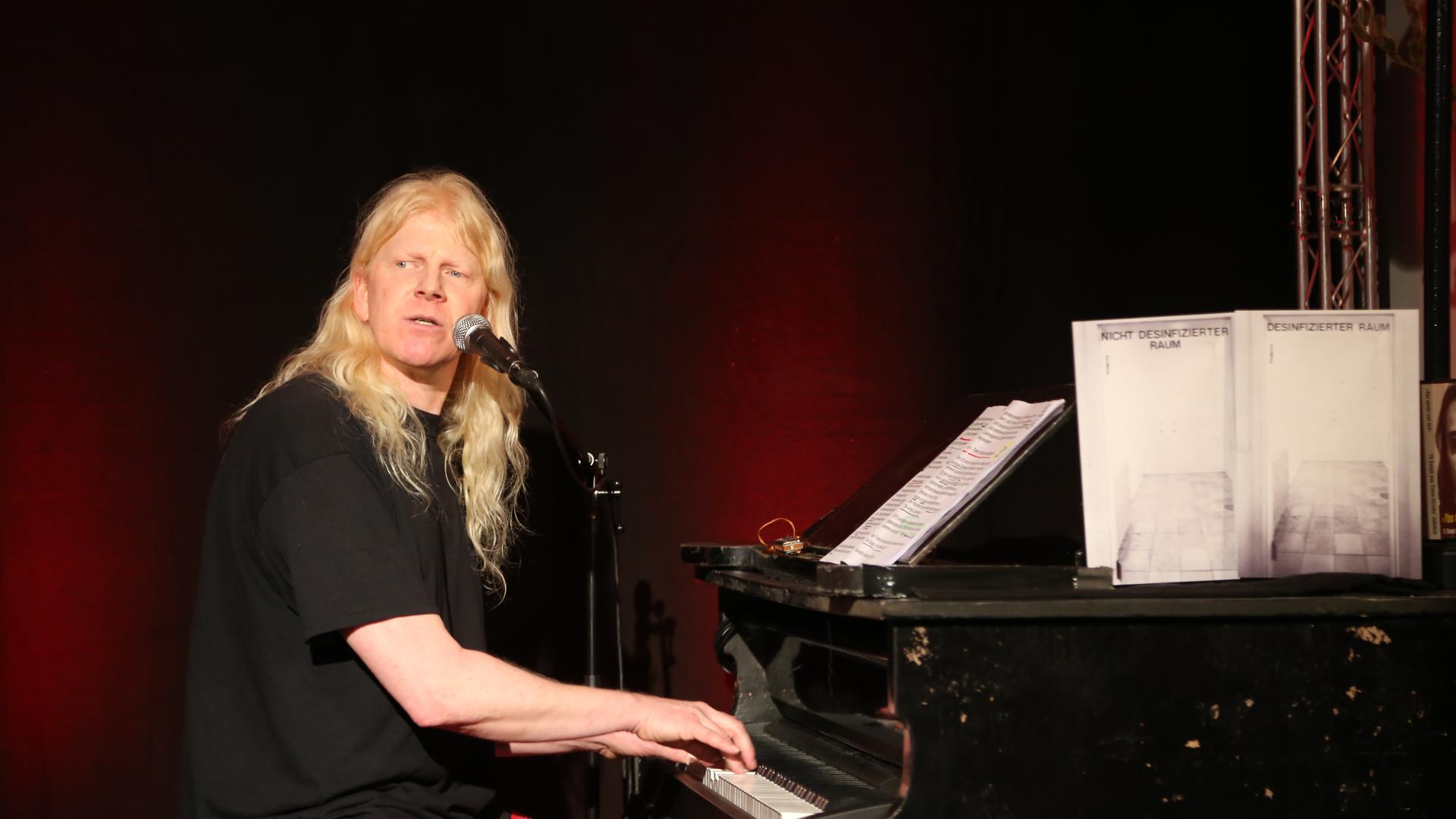 Der Mann am Klavier ist Musiker, Kabarettist, Puppenspieler und mittlerweile sogar professioneller Bühnenpyrotechniker: Gunzi Heil. Das Foto entstand am 6. März 2020 kurz vor dem ersten Lockdown bei der Eröffnung einer Ausstellung von Timm Ulrichs in Berlin. 