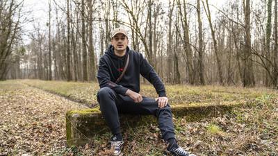 David Bošnjak, besser bekannt als Haze, sitzt auf einem Stein, hinter ihm ist ein Waldstück zu erkennen.
