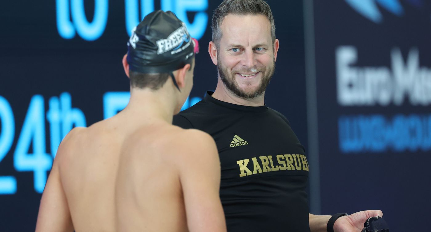 Jonas Holzwarth unterhält sich mit einem Schwimmer