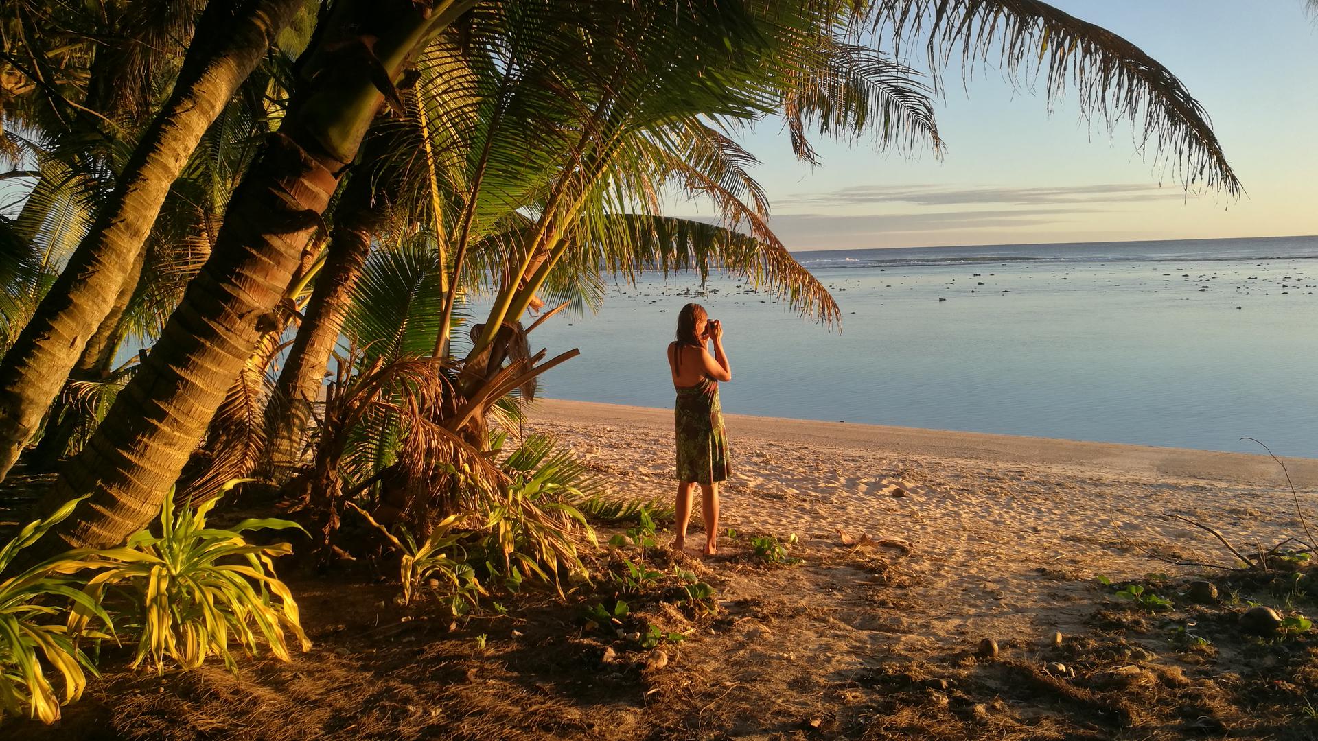 Sarah Polzer am Strand mit einer Kamera in der Hand