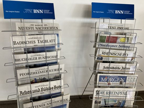 Verschiedene Tageszeitungen sind in zwei Zeitungsständern einsortiert.