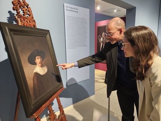 Zwei Personen vor einem Gemälde, eine Rembrandt-Kopie.