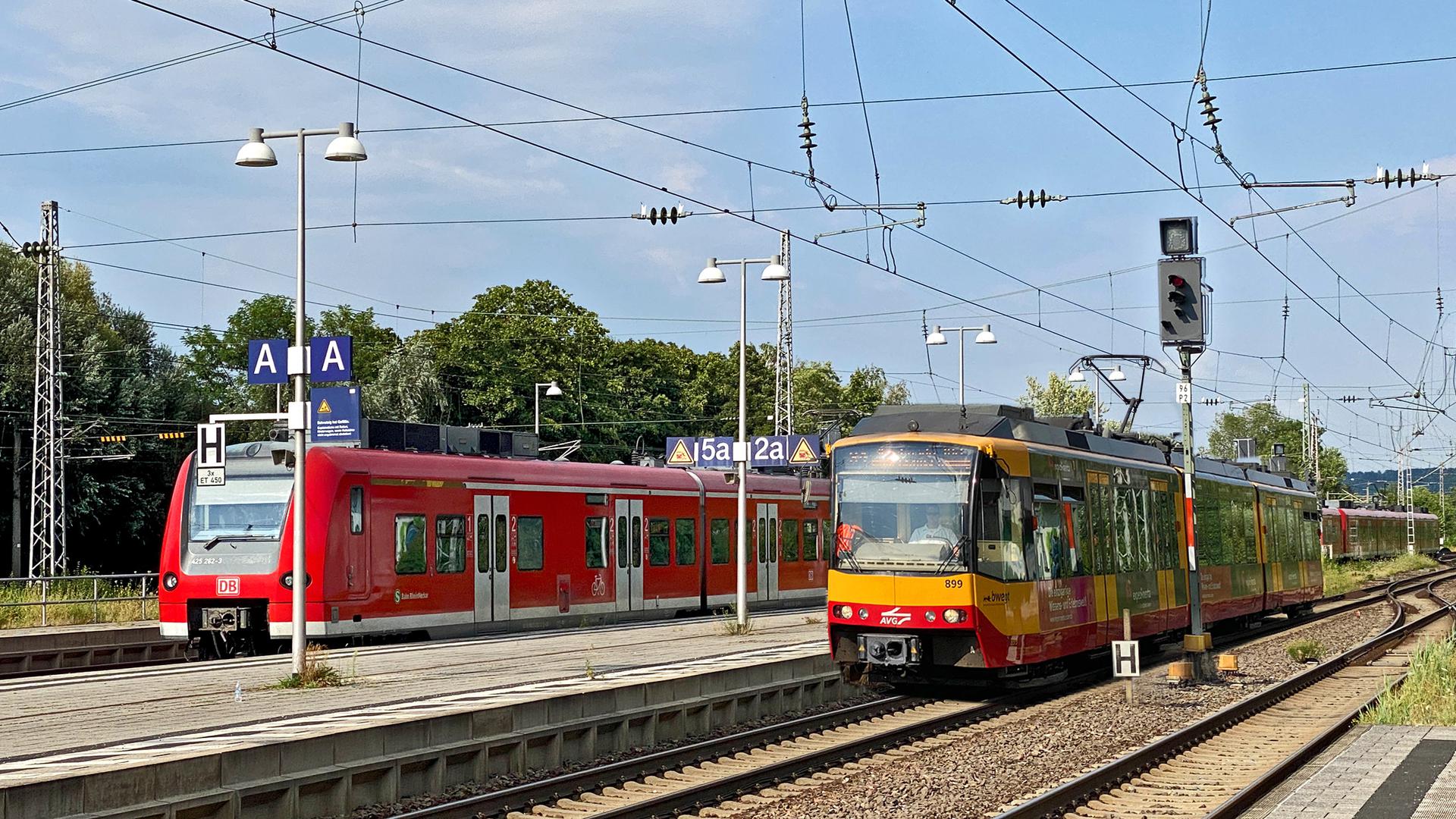 Ein roter Regionalexpress (links) und eine gelbe Stadtbahnlinie.