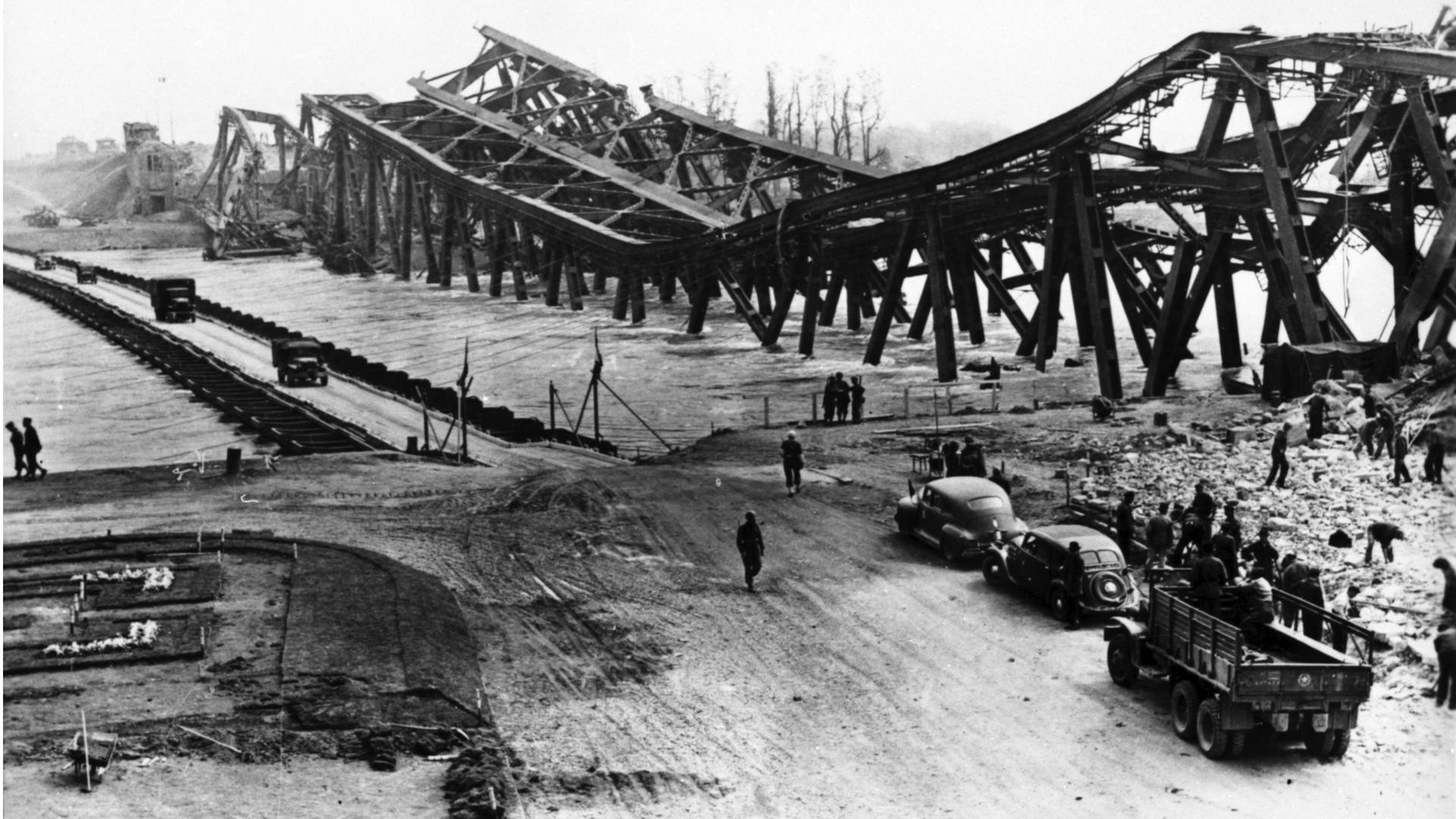Zerstört und provisorisch ersetzt: Die Rheinbrücke liegt im April 1945 im Wasser. Über die Behelfsbrücke können die Menschen weiter zwischen Karlsruhe und Wörth hin und her fahren.