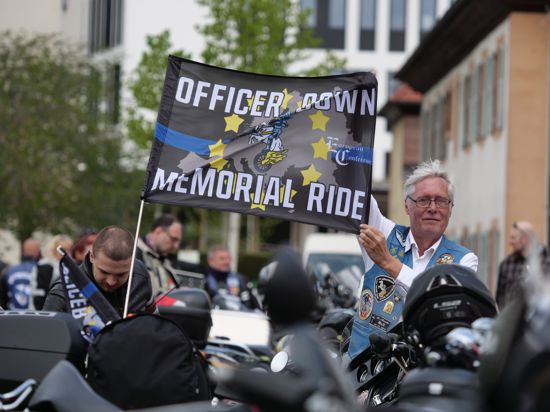 Holk Opitz aus Münster ist Europa-Präsident der Blue Knights und hält eine Flagge für die Ausfahrt.