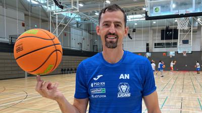Aleksandar Nadjfeji balanciert einen Basketball in der Karlsruher Lina-Radke-Halle