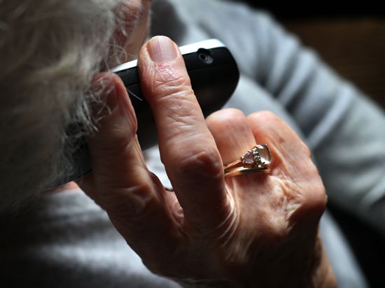 Eine ältere Frau telefoniert mit einem schnurlosen Festnetztelefon