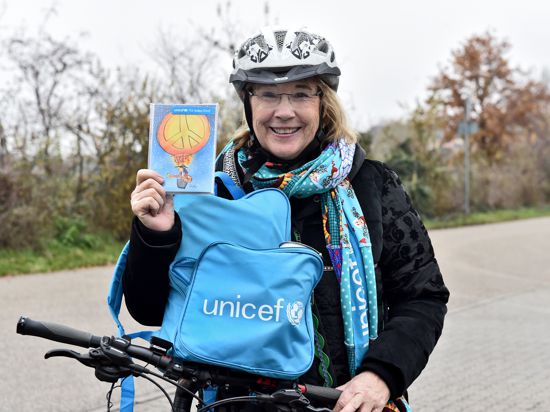 Ursula Grass liefert als eine „Blaue Radlerin“ Unicef-Postkarten nach Hause. 