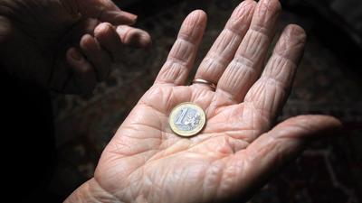 ARCHIV - ILLUSTRATION - Eine 83-jährige Frau hält am 17.03. 2013 in Würzburg (Bayern) eine Euromünze. Foto: Karl-Josef Hildenbrand/dpa (zu dpa «Bundesregierung warnt vor drohender Altersarmut» vom 26.10.2016) +++ dpa-Bildfunk +++