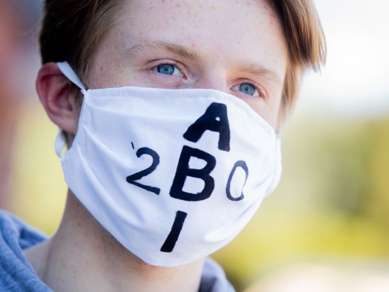 Ein Schüler trägt wegen des Coronavirus eine Schutzmaske mit der Aufschrift "Abi 2020".