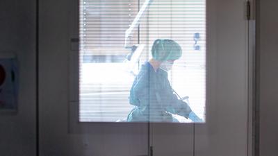 Eine Krankenschwester auf der Infektionsstation der Uniklinik Essen versorgt in Schutzkleidung und mit einer Atemmaske einen Patienten. (zu dpa: «Unterdruck und Schutzkleidung: Isolierstation betreibt großen Aufwand») +++ dpa-Bildfunk +++