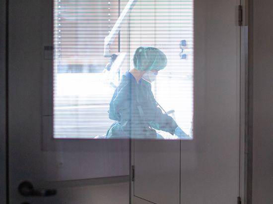 Eine Krankenschwester auf der Infektionsstation der Uniklinik Essen versorgt in Schutzkleidung und mit einer Atemmaske einen Patienten. (zu dpa: «Unterdruck und Schutzkleidung: Isolierstation betreibt großen Aufwand») +++ dpa-Bildfunk +++