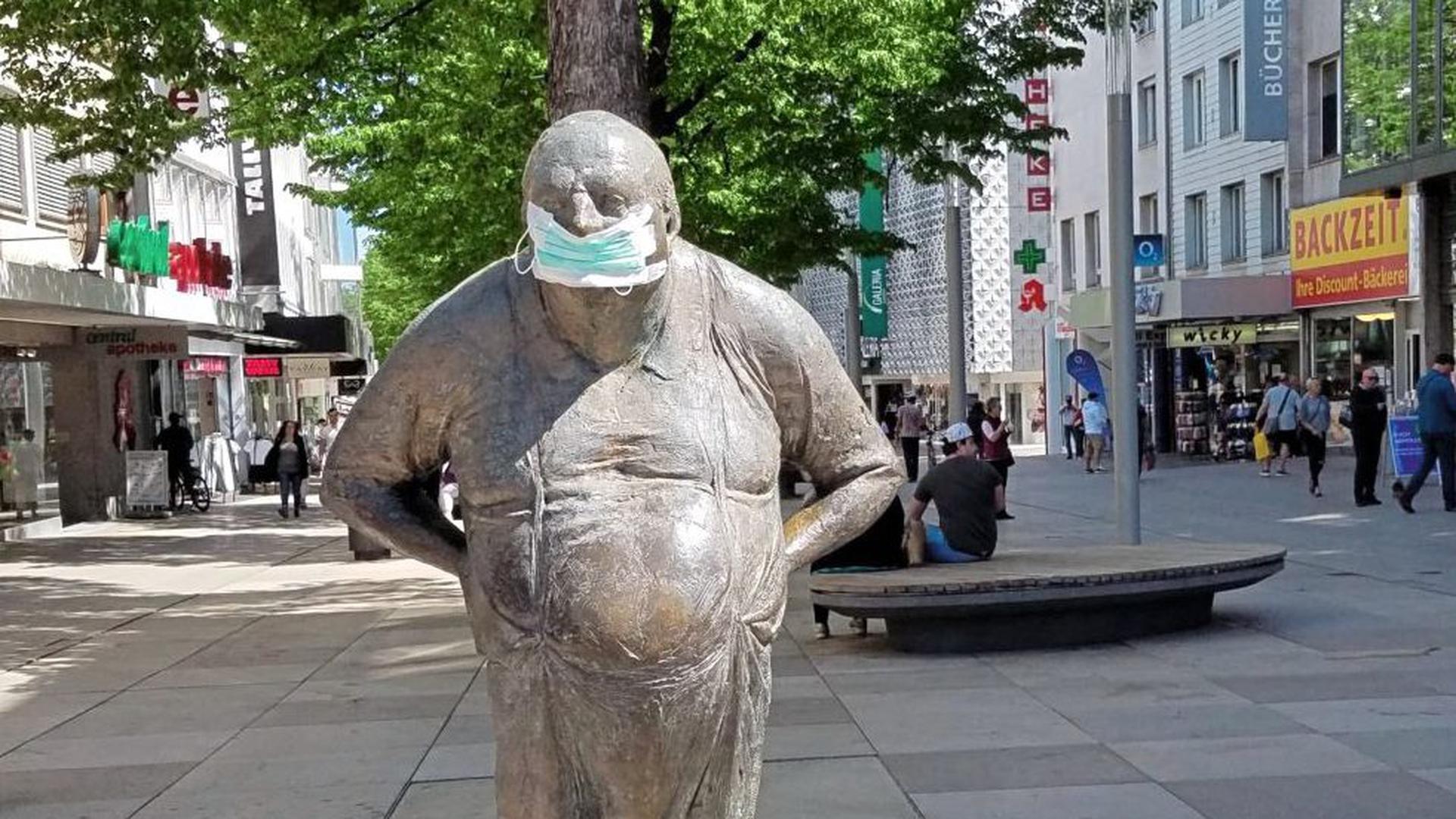 Eine Statue mit Mundschutz steht in der Fußgängerzone