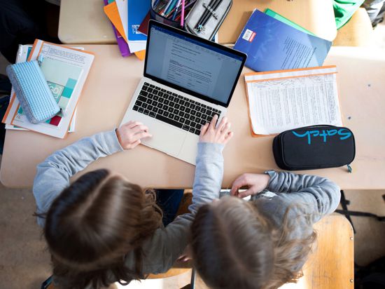 Schüler einer fünften Klasse eines Gymnasiums benutzen im Unterricht einen Laptop.