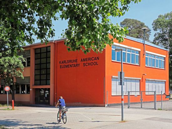 Amerikaner in Karlsruhe: In der Nordstadt weist vieles noch heute auf die Zeit hin, als US-Bürger das Viertel bewohnten. Während die Bekleidung des Radfahrers wohl Zufall ist, trägt die Elementary School ihren Namen aus gutem Grund.