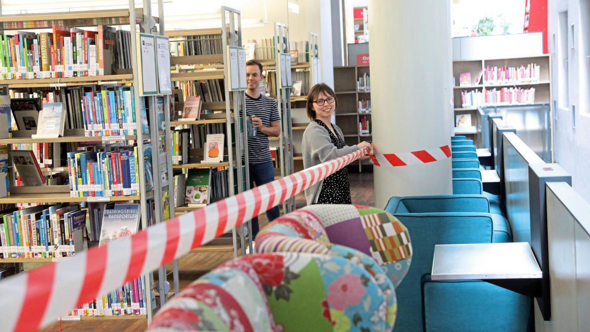 Begrenztes Lesevergnügen: Jan Roth und Anastasia Keppel sperren in der Stadtbibliothek im Ständehaus alle Sitzgelegenheiten ab. Nur Ausleihe ist möglich