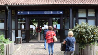 Drei Frauen stehen Schlange vor dem KVV-Kundenzentrum am Ettlinger Stadtbahnhof.