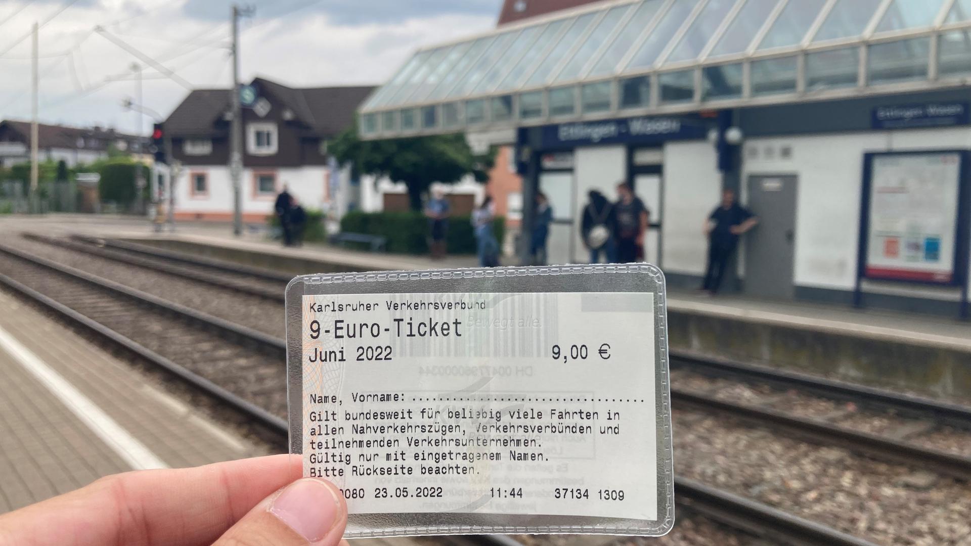Ein 9-Euro-Ticket, im Hintergrund sieht man die Haltestelle Ettlingen Wasen.
