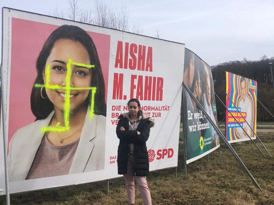 Lässt sich nicht unterkriegen: Aisha Fahir, Kandidatin der SPD aus dem Wahlkreis Ettlingen für die Landtagswahl, vor ihrem mit einem Hakenkreuz beschmierten Wahlplakat in Karlsbad.