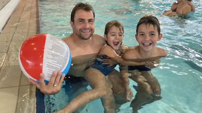Jens Helfer (links) ist mit seinen Kindern Leon und Lotte im Wasser. Sie haben einen Wasserball dabei.