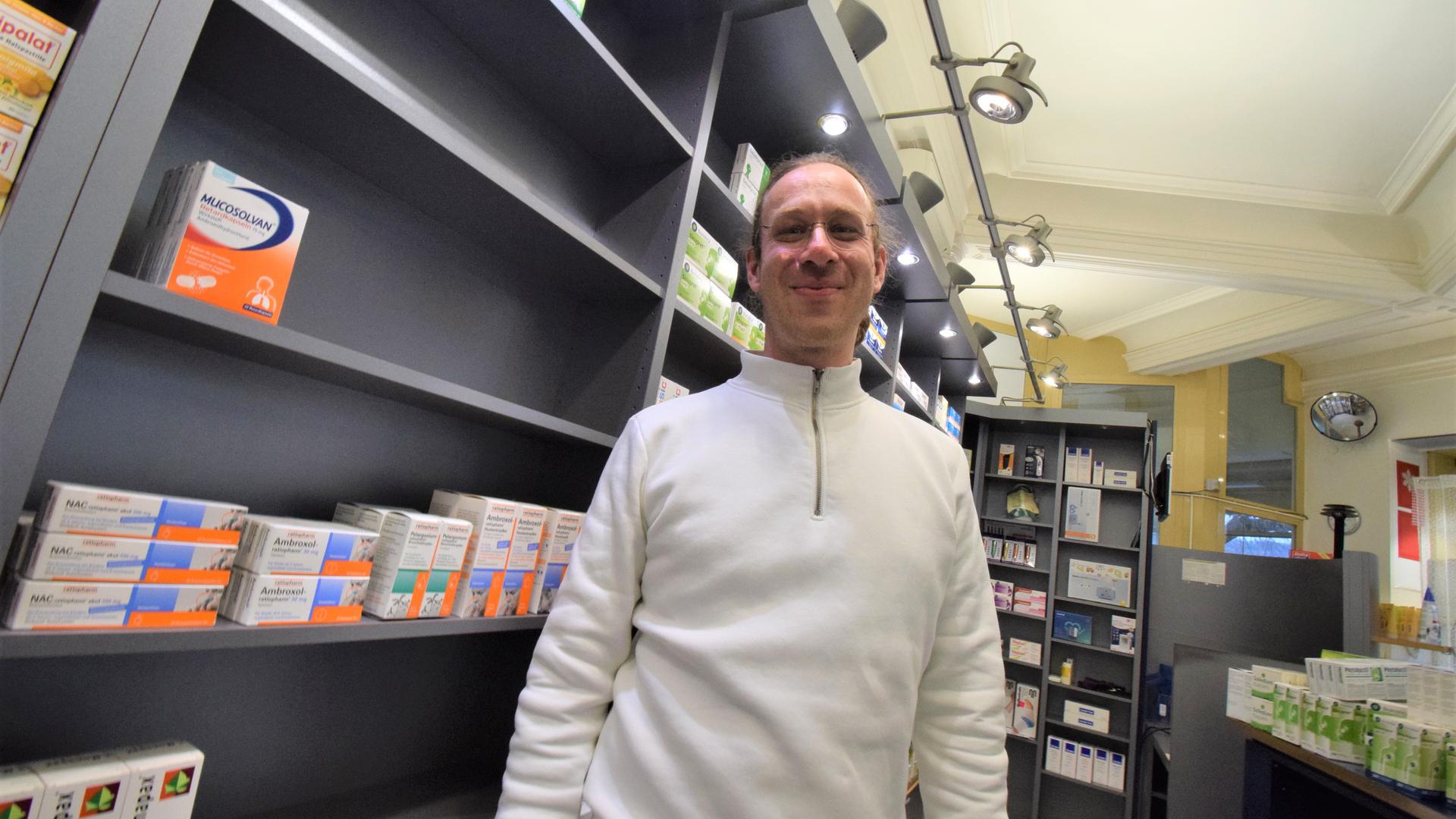 Christopher Buchta, Inhaber der Apotheke am Stadtgarten Ettlingen, steht vor dem teils leeren Medikamentenregal im Verkaufsraum. 