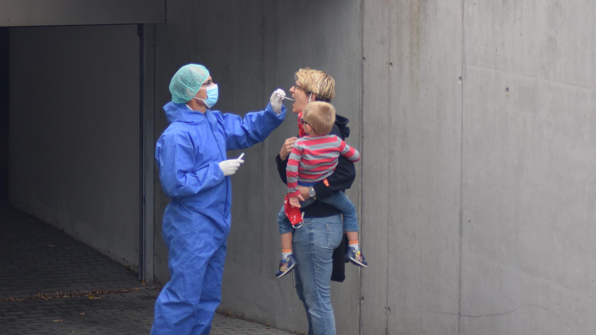 Einmal Mund auf bitte: Im Schutzanzug nimmt Hausarzt Benno Greiner in der Zufahrt zur Tiefgarage Abstriche von Menschen, die sich auf das Corona-Virus testen lassen wollen.