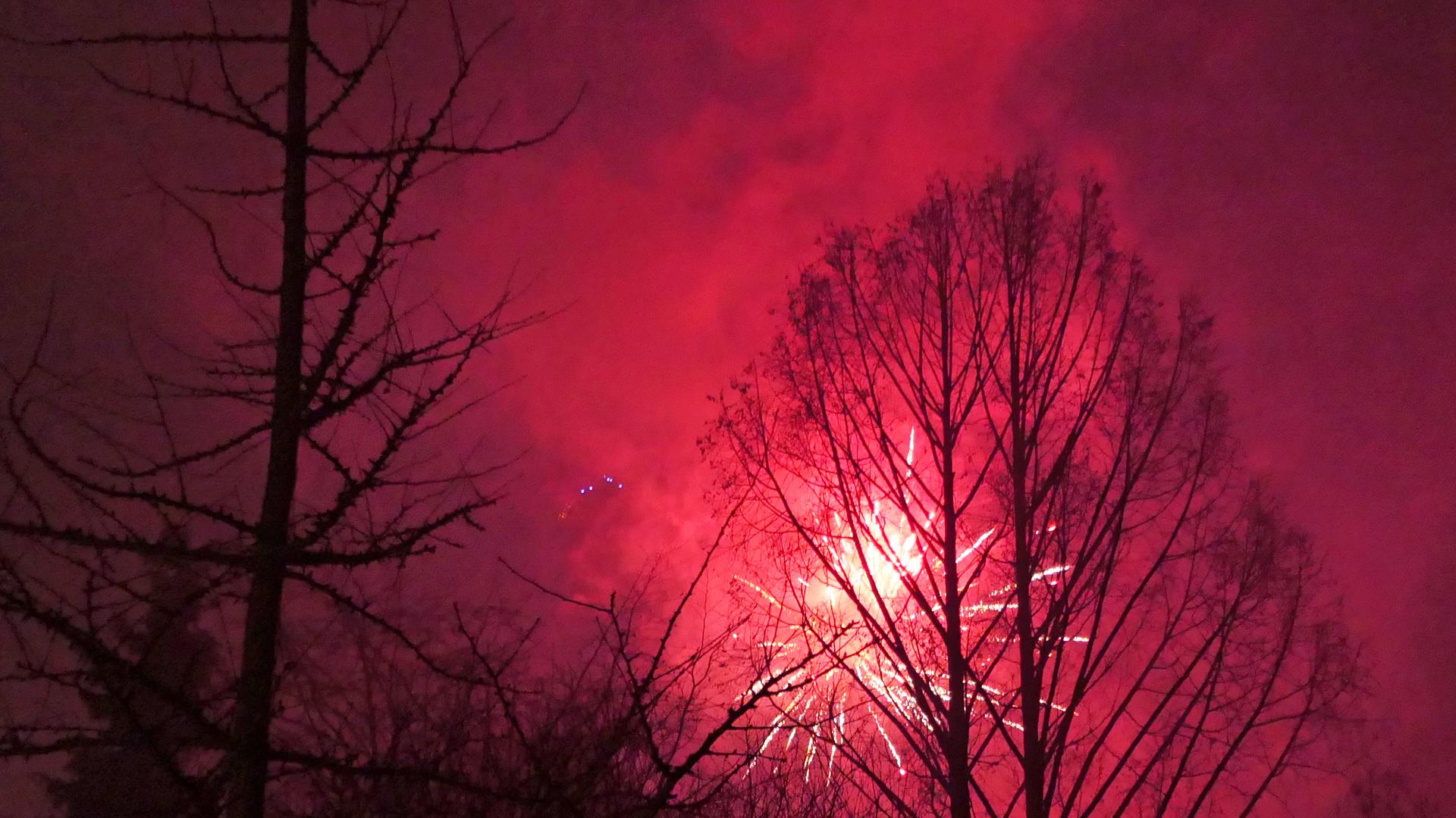 Roter Himmel und Strahlen von Feuerwerksrakete