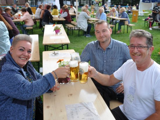 Susi Wirth, Reinhard Gräfinger und Thomas Steidl (von links) prosten sich zu. 2021 fiel das Ettlinger Marktfest wegen der Corona-Auflagen aus. Stattdessen errichteten Vereine in der Stadt mehrere Biergärten. 