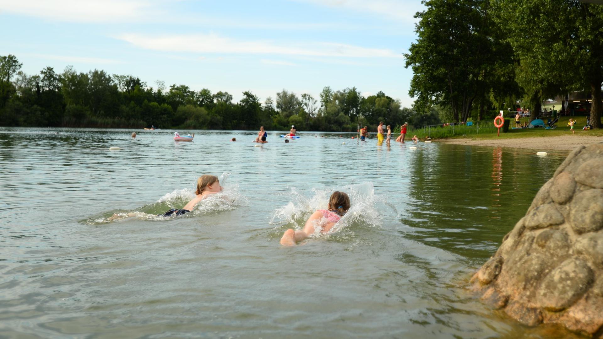 Zwei niedliche Kinder haben Spaß im Wasser des Buchtzigsees.