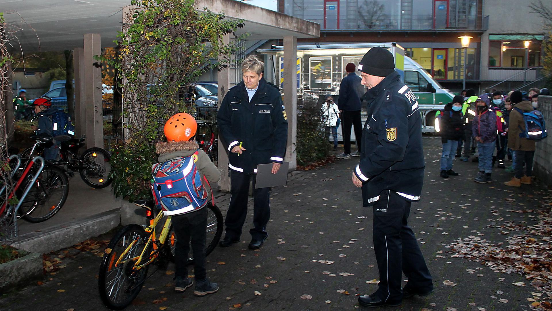 Zwei Polizisten, ein Kind mit Fahrrad