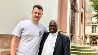 David Seifried von der KjG St. Martin mit Priester John Moyo vor der Martinskirche in Ettlingen.