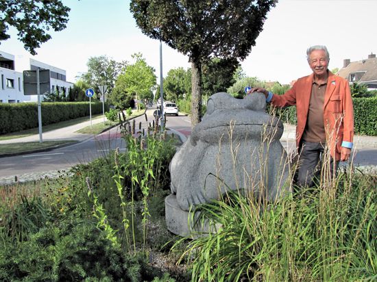Der Frosch grüßt am Ortseingang: Der Bruchhausener Ortsvorsteher Wolfgang Noller neben der übergroßen steinernen Skulptur, die im Kreisverkehr auf der Landstraße von Ettlingen kommend steht.
