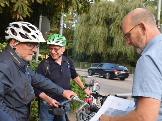 Der Chef des Ettlinger Stadtplanungsamts, Wassili Meyer-Buck (rechts), erklärt Verkehrsminister Winfried Hermann (links) die Idee eines Minikreisels, der Radfahrern eine schnellere Einfahrt in die Wasenstraße und weiter zur Rheinstraße ermöglichen soll.